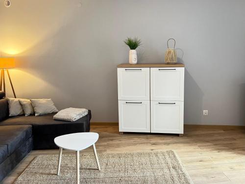 a living room with a couch and a white cabinet at Kawalerka Łódź 51 in Łódź