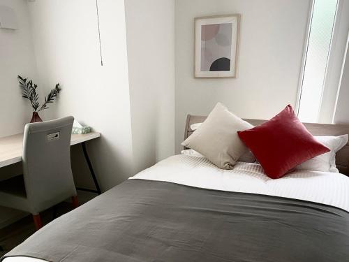 a bedroom with a bed with red and white pillows at Y's INN Nakai 005T in Tokyo