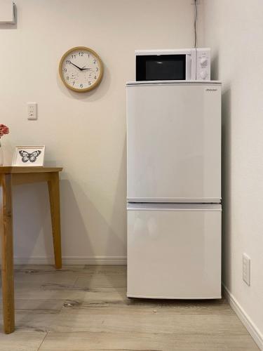 a white refrigerator with a microwave on top of it at Y's INN Nakai 005T in Tokyo