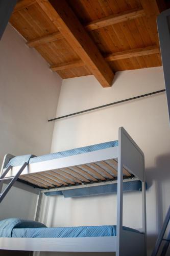 a bunk bed in a room with a wooden ceiling at Ostello Cammino di Francesco in Rivodutri