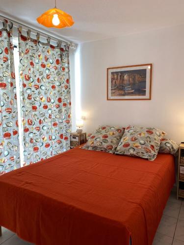 - une chambre avec un lit doté d'un couvre-lit rouge dans l'établissement Appartement T4 avec terrasse et parking 50 m de la plage -V0744, à Vias