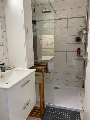 une salle de bain blanche avec une douche et un lavabo dans l'établissement Appartement T4 avec terrasse et parking 50 m de la plage -V0744, à Vias