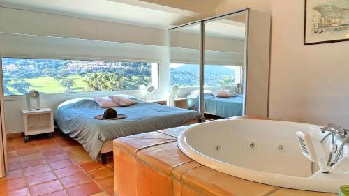 une salle de bain avec baignoire et une chambre avec un lit dans l'établissement Villa Les Amandiers, à Sainte-Maxime
