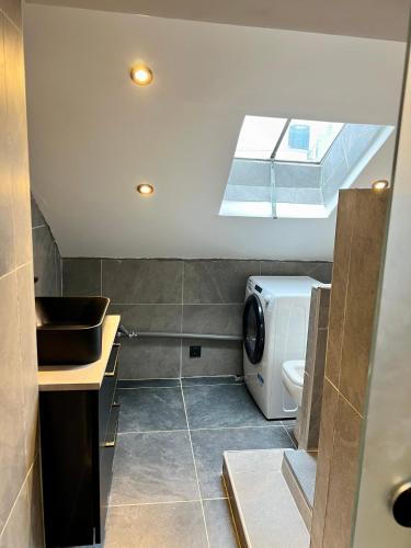 une salle de bains avec lave-linge et lavabo dans l'établissement Appartement, à Neuilly-sur-Seine