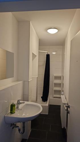 a white bathroom with a sink and a shower at Case Five Aparthotel mit Parkplatz in Datteln