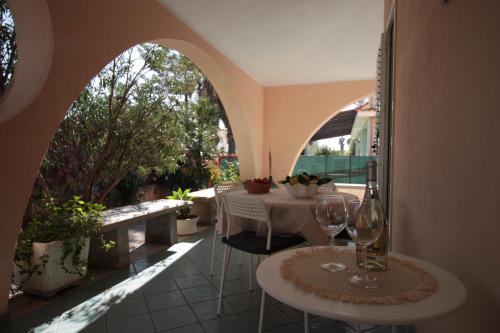 an outdoor patio with two tables and two wine glasses at VILLA CALA BERNARDO 2 Appartamenti in Calabernardo