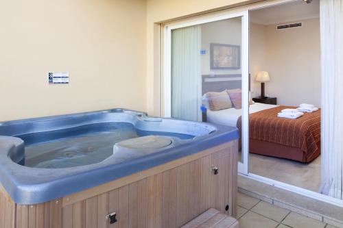 a large blue tub in a bedroom with a bed at Malibu Mansions by the beach by ALFRESCO STAYS in Mijas Costa