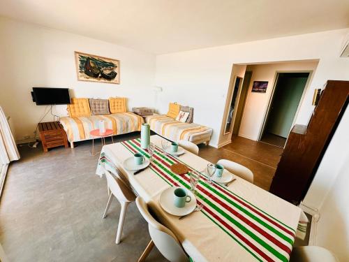 un salon avec une table et un canapé dans l'établissement L'Océanide face à la mer, au Grau-du-Roi