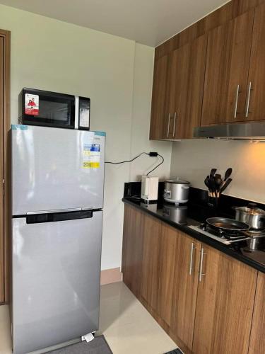 une cuisine avec un réfrigérateur et un micro-ondes dans l'établissement M S Staycation, à Manille