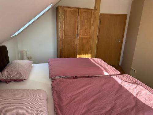 a bedroom with two beds with pink sheets and a closet at Ferienwohnung am Mühlenwanderweg in Straufhain