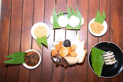 a group of plates of food on a wooden table at Eliyanth Udawalawe in Udawalawe