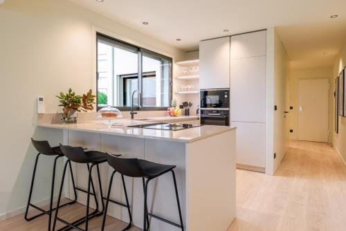 a kitchen with a large island with bar stools at HostWise - Stylish Flat with Terrace & Garage in Porto