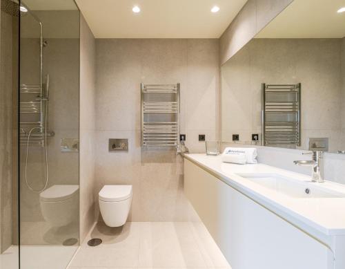 a bathroom with a toilet and a sink and a shower at HostWise - Stylish Flat with Terrace & Garage in Porto