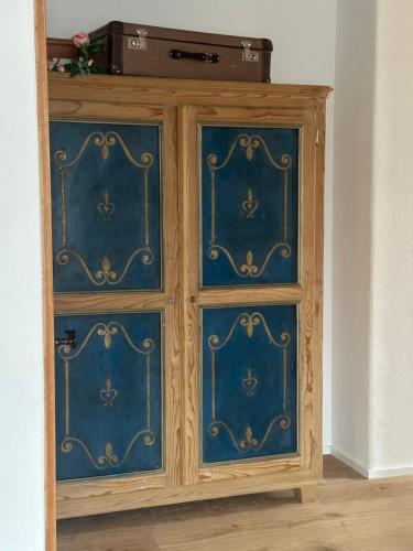 a wooden cabinet with blue doors in a room at Haus Berger in Bayrischzell
