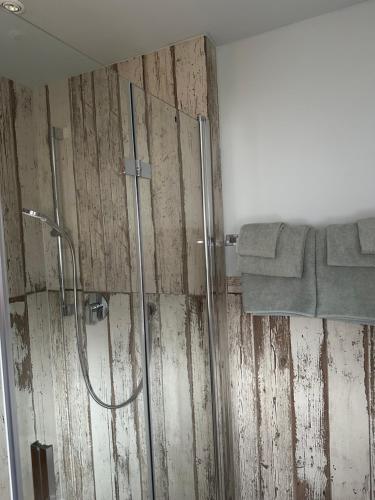 a bathroom with a shower and a wooden wall at Haus Berger in Bayrischzell