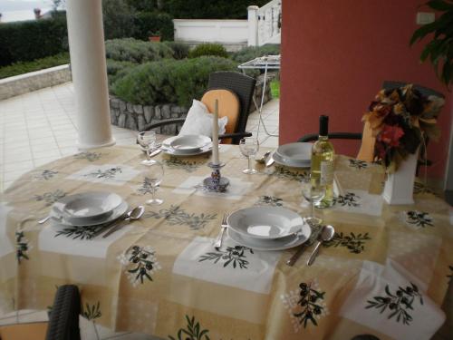a table with a table cloth with plates and wine glasses at Villa Antonio in Opatija