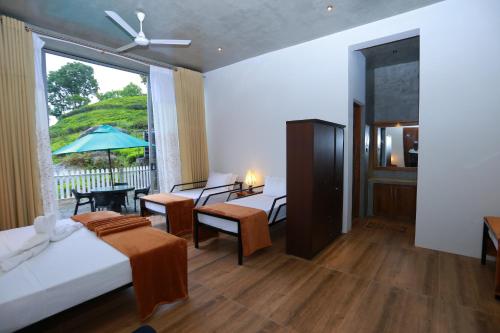 a bedroom with a bed and a living room with a window at Tara Waterfall in Rakwana