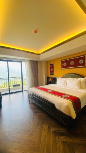 a bedroom with a large bed with a large window at Fansipan View Hotel in Sa Pa