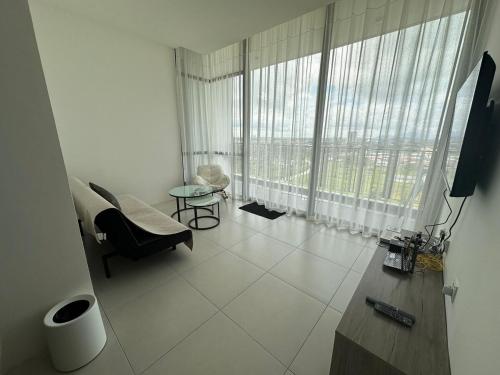 a living room with a large window and a couch at Podium Premium Homestay in Kuching