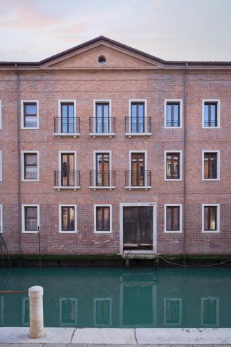 a brick building with windows and water in front at Palazzo dei Guardiani in Venice