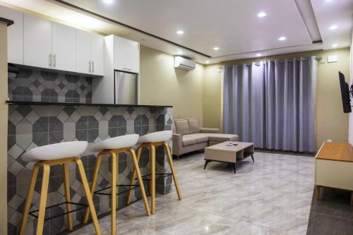 a lobby with a bar with stools and a couch at Aylane Aparth Hotel in Nampula