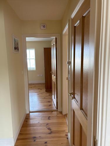 an empty hallway with wooden floors in a home at Number 2 Bank House in Schull