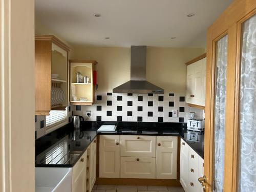 a kitchen with black and white tiles on the wall at Number 2 Bank House in Schull
