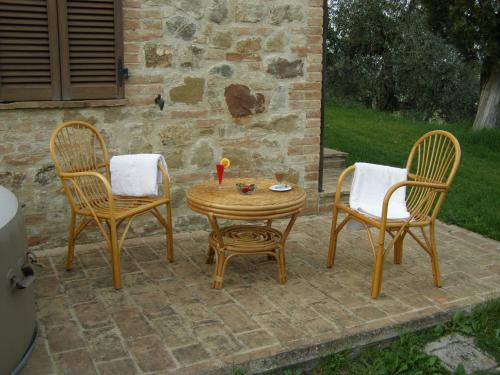 two chairs and a table with a candle on a patio at Agriturismo Collesassi in Montalcino