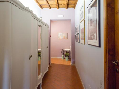 フィレンツェにあるTorrigiani Apartmentの白い壁とウッドフロアの客室につながる廊下