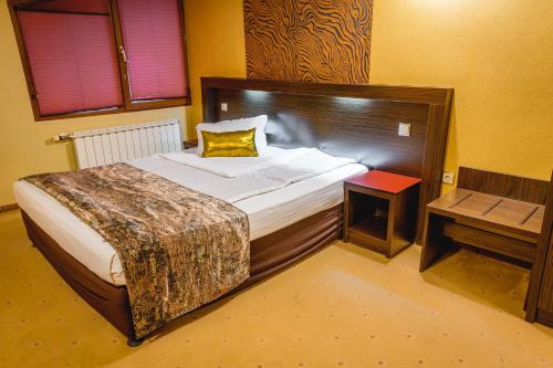 a bedroom with a large bed with a yellow pillow at Eleganza Family Hotel - Free Parking in Sofia