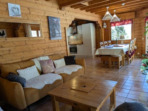 un salon avec un canapé et une table dans l'établissement Le Chalet de Philippe, à La Bresse