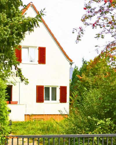 a white house with red shutters and a fence at München Haus-Centrum-Messe-Oktoberfest -7-24 CHECKIN in Munich