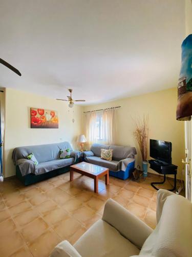 a living room with a couch and a tv at Casa Sierra in La Puerta de Segura