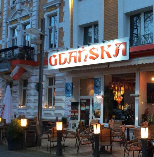 a restaurant with tables and chairs in front of a building at Hotelik Gdanska in Oberhausen