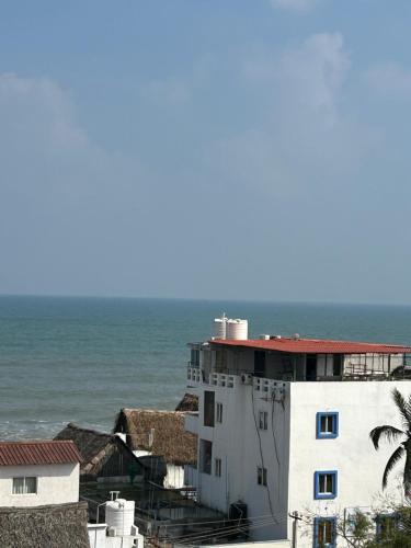 a white building with the ocean in the background at The Elite Beachview in Puducherry