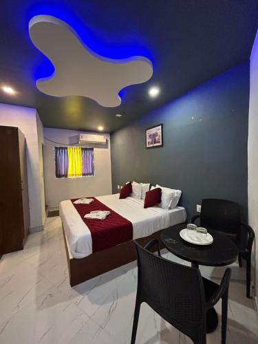 a bedroom with a bed and a table with chairs at The Elite Beachview in Puducherry