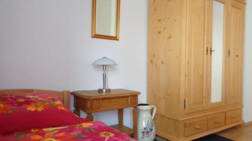 Schlafzimmer mit einem Bett und einem Holzschrank in der Unterkunft Pension Hans Rastatt in Rastatt