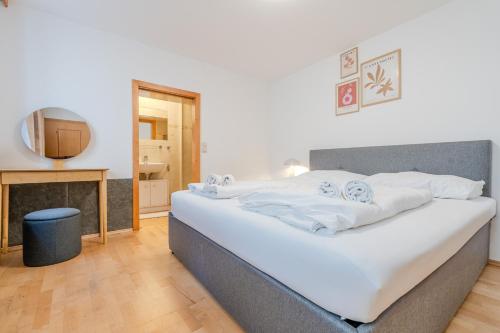 a large white bed in a room with a television at Whats-App Self-Check-IN - Bad Aussee City House in Bad Aussee
