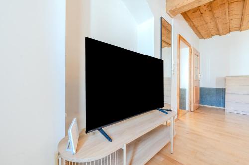 a flat screen tv on a stand in a living room at Whats-App Self-Check-IN - Bad Aussee City House in Bad Aussee