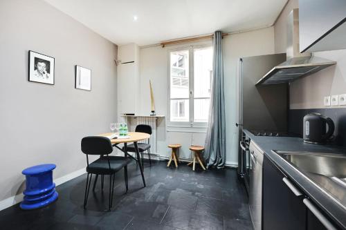 une cuisine avec une table, des chaises et un évier dans l'établissement Spacieux 2P à Paris, rue Jouffroy d'Abbans proche Arc de Triomphe, à Paris