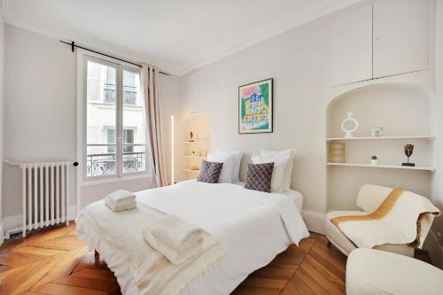 une chambre blanche avec un lit blanc et une chaise dans l'établissement Spacieux 2P à Paris, rue Jouffroy d'Abbans proche Arc de Triomphe, à Paris