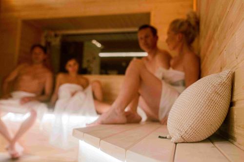 a group of people in white dresses sitting in a bathroom at Resort Mlýn Karolínka in Vranov nad Dyjí