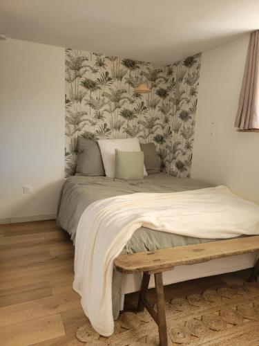 - une chambre avec un grand lit et un banc en bois dans l'établissement Studio SIMONE, à 2 pas de la plage, à Saint-Gilles-Croix-de-Vie