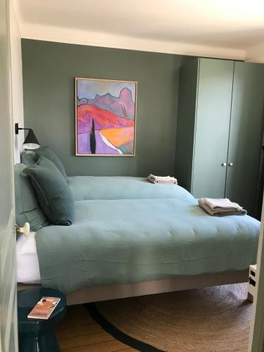 - une chambre avec un grand lit vert orné d'une peinture murale dans l'établissement Un nid douillet en plein centre, à Chartres