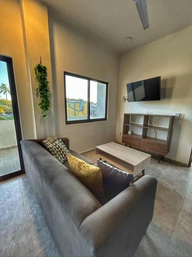 a living room with a couch and a tv at Apolo Apartment, near the beach with pool in Barra de Navidad