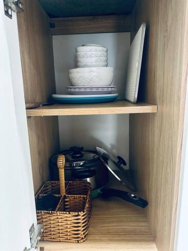 a cupboard with plates and dishes and a basket at Trang Dream House Phan Rang in Kinh Dinh