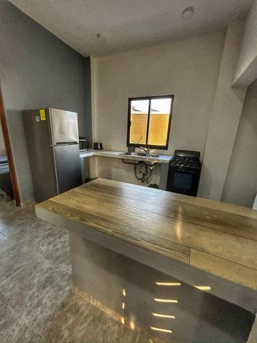an empty kitchen with a counter and a refrigerator at Apolo Apartment, near the beach with pool in Barra de Navidad