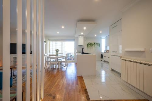 a kitchen and dining room with white cabinets and a table at Brisa do Oceano in Ovar
