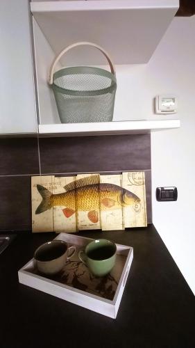a table with two cups and a basket on a shelf at Lake in Nature in Consiglio di Rumo