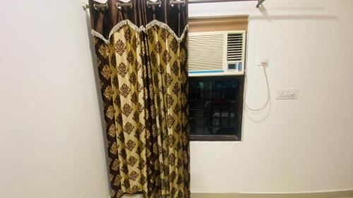 Cette chambre dispose d'une fenêtre avec des rideaux et de la climatisation. dans l'établissement Comfy Homes- Fully Furnished Independent Floor, à Amritsar